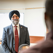 Le sénateur Dhillon revêtu d'un complet et d'un turban se tient debout à l'avant d'une salle de classe et parle à des aspirants policiers de la GRC.