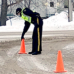 Un cadet place des cônes de signalisation sur les lieux d'une collision simulée.