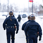 Trois cadets portant des chapeaux de fourrure et des manteaux d'hiver marchent sur une rue enneigée.