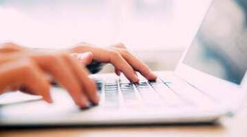 Doigts qui touchent un clavier et qui tapent les mots « signalez un crime ».