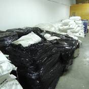 Des palettes de sacs et des fûts de produits chimiques trouvés et saisis lors de l’exécution du mandat de perquisition.