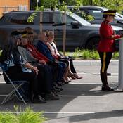 L’animatrice, la sergente-major d’état-major Kathleen Darby, au podium, prononçant un discours.