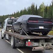 Une Dodge Challenger noire à l’arrière d’une dépanneuse sur la route 1 près de Golden, en Colombie-Britannique