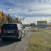 Une voiture de patrouille fantôme de la Patrouille routière de la Colombie-Britannique avec ses feux d’urgence allumés devant un panneau de zone de construction sur la Route 97 près de Prince George