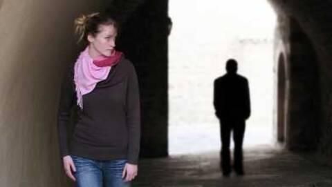 Personne marchant avec la silhouette noire d’une autre personne derrière elle.