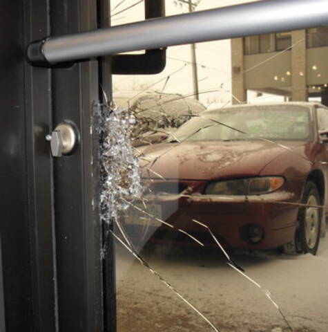 Photo de la porte d’un commerce avec bris de verre